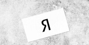 Top view of a minimalist workspace featuring a notepad, coffee cup, and accessories on a concrete surface.